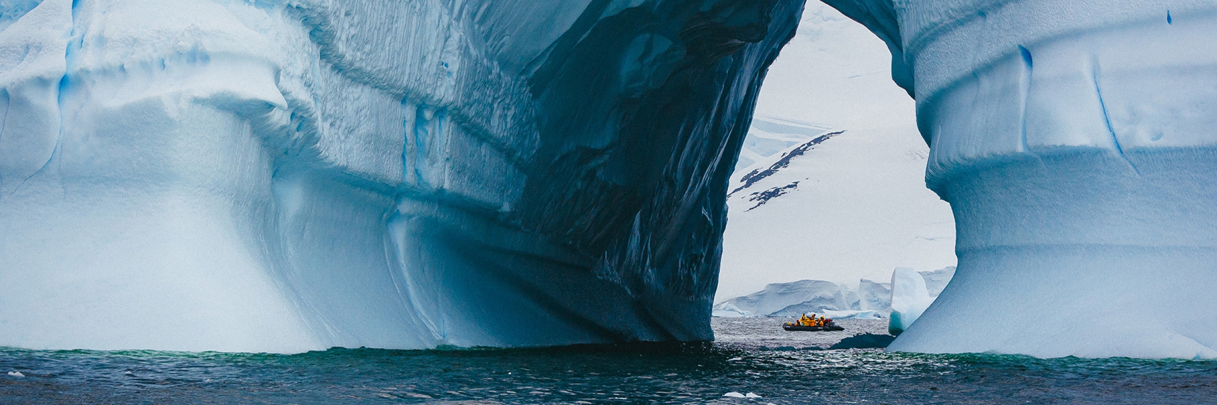 A zodiac spotted through an iceberg, in the Antarctic Peninsula. Photo: David Merron