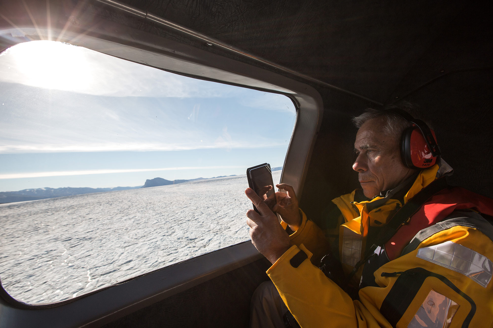 Passenger taking a photo of Arctic landscape from helicopter